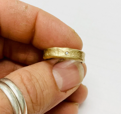 hand molded 5.5 mm wide gold band with diamond