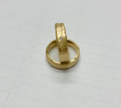 hand molded 5.5 mm wide gold band with diamond